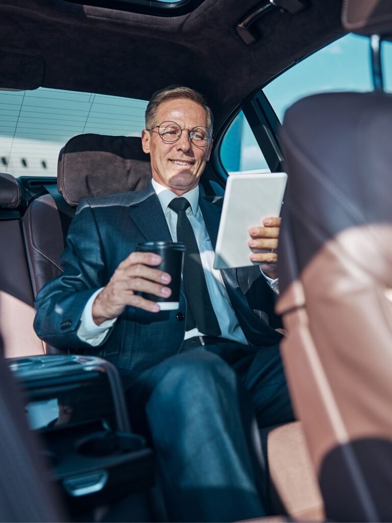 Customer sitting in the back reading a note while travelling on a quick chauffeur ride